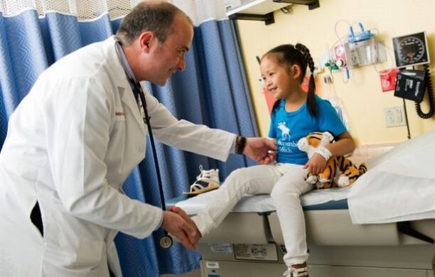 բժիշկը զննում է ազդրի արթրոզով հիվանդ երեխային